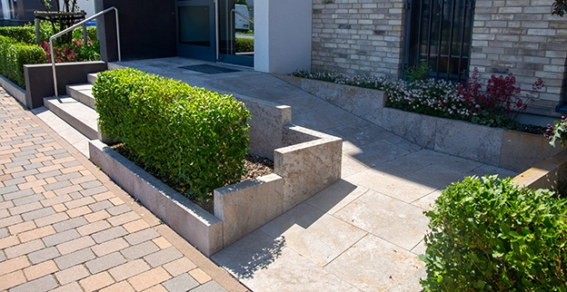 A landscaped entrance with stone steps and ramps.
