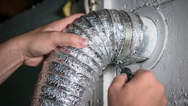 Mr. Handyman fixing a dryer vent.