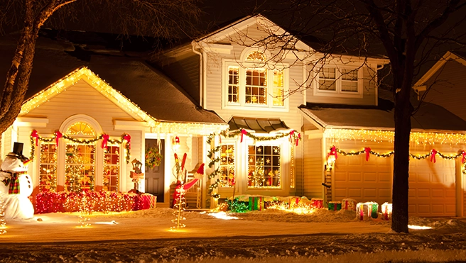 A festively decorated house at night, adorned with colorful lights.