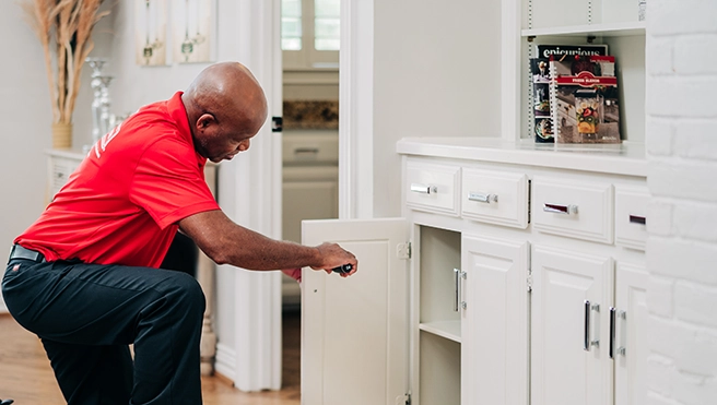 MRH employee working on cupboard door.