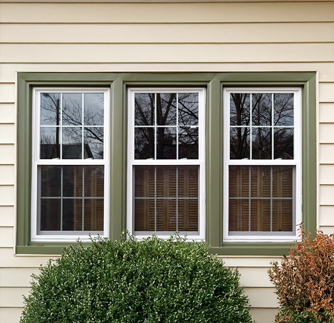 Three white-framed windows with green trim.