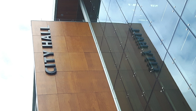 Exterior of a modern city hall building featuring wooden panels.