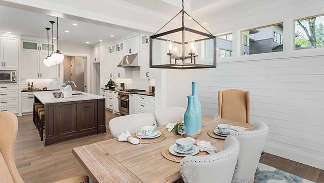Modern kitchen and dining area featuring a wooden table set.