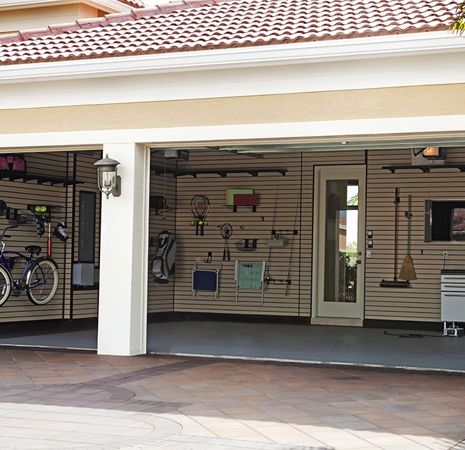 A neatly organized garage features bikes and various tools on wall-mounted shelves.